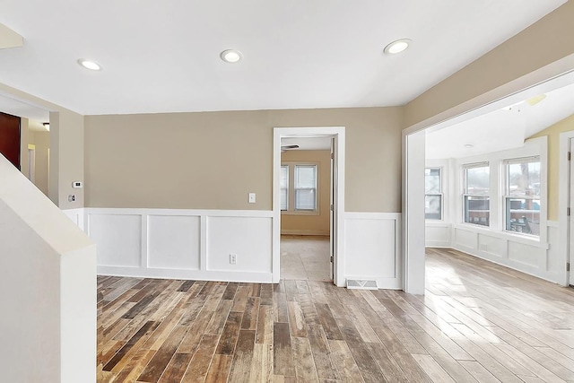 unfurnished room with wainscoting, wood finished floors, and recessed lighting