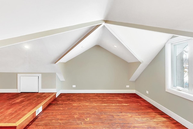 additional living space featuring vaulted ceiling, wood finished floors, and visible vents