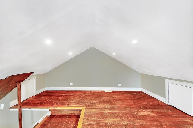 additional living space with vaulted ceiling and hardwood / wood-style floors