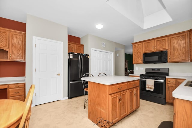 kitchen featuring black appliances, a breakfast bar, and a center island