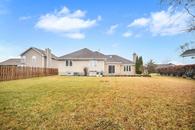 rear view of property with a lawn and central AC