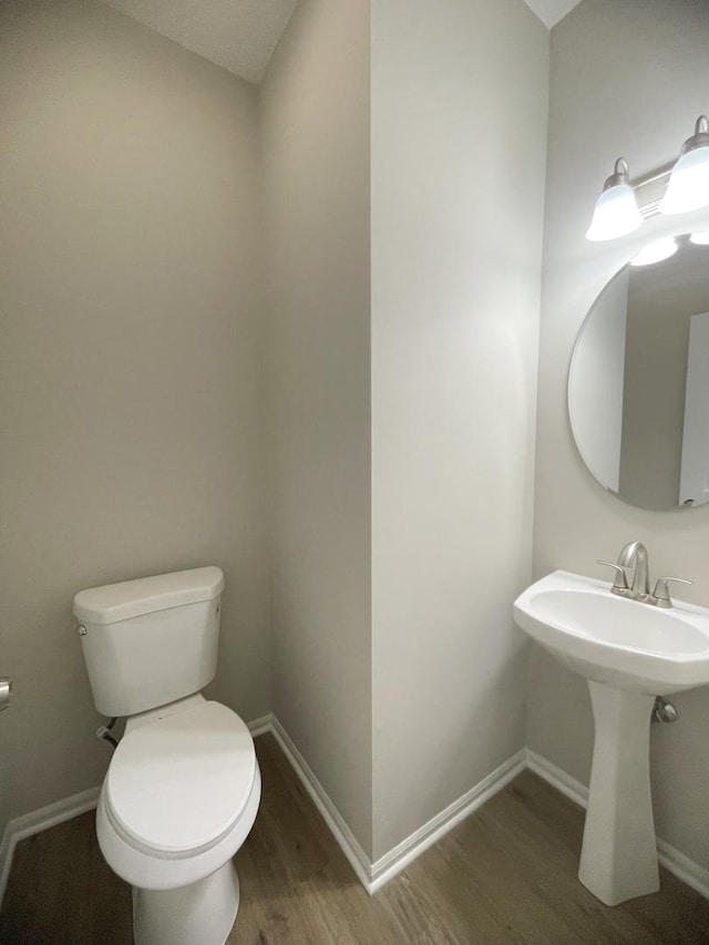 bathroom featuring hardwood / wood-style flooring, toilet, and sink