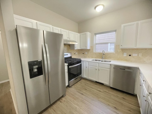 kitchen with backsplash, white cabinets, sink, light wood-type flooring, and appliances with stainless steel finishes