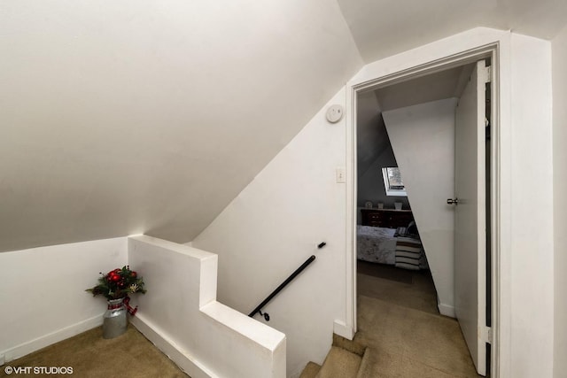 stairway with carpet flooring and lofted ceiling