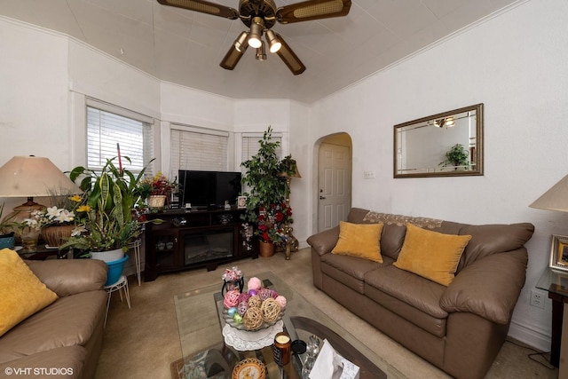 carpeted living room with ceiling fan and crown molding