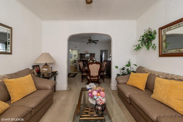 living room featuring ceiling fan, crown molding, and light carpet