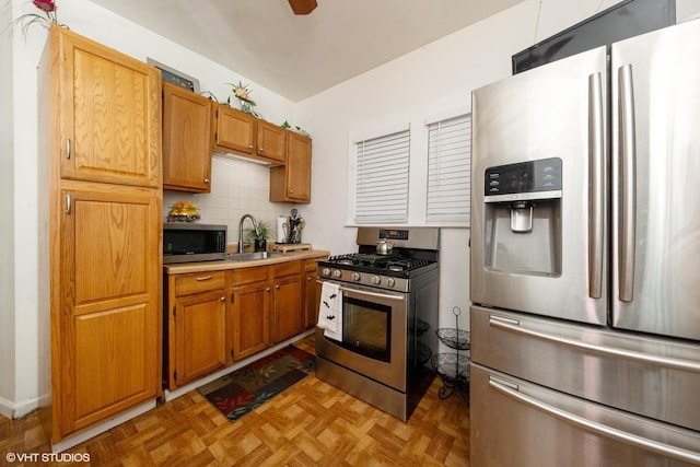 kitchen featuring backsplash, sink, stainless steel appliances, and light parquet floors