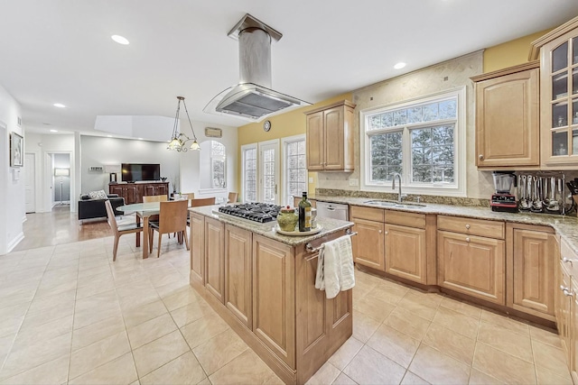 kitchen with light stone counters, a sink, stainless steel gas cooktop, and island range hood