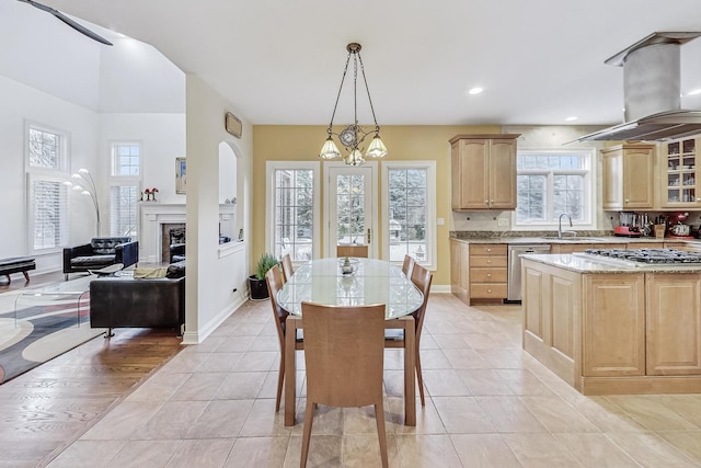 kitchen featuring island exhaust hood, light brown cabinets, gas cooktop, and dishwasher