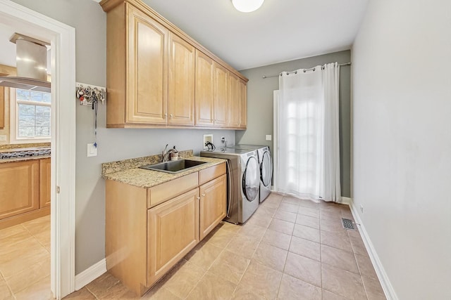 laundry room featuring cabinet space, baseboards, visible vents, washing machine and clothes dryer, and a sink