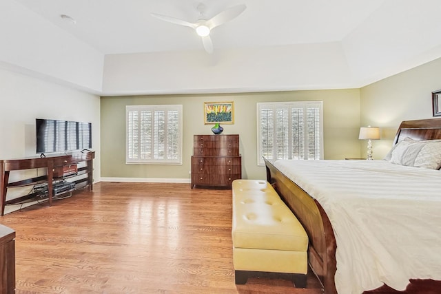 bedroom with ceiling fan, wood finished floors, and baseboards