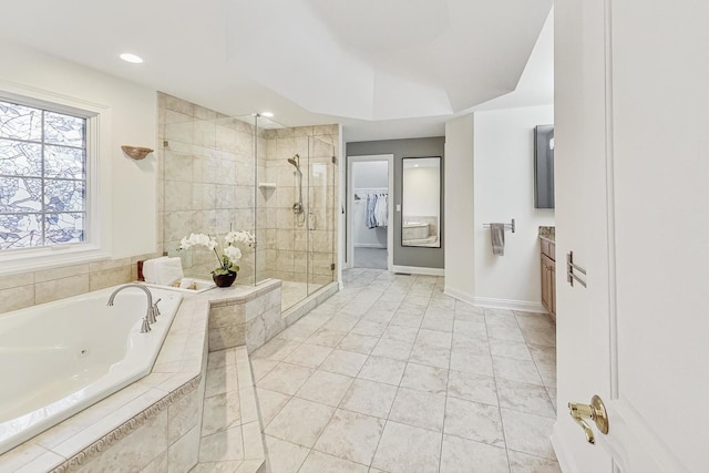 bathroom featuring a walk in closet, a shower stall, tile patterned flooring, baseboards, and a tub with jets