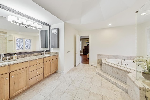 full bathroom with a bath, tile patterned flooring, double vanity, and a sink