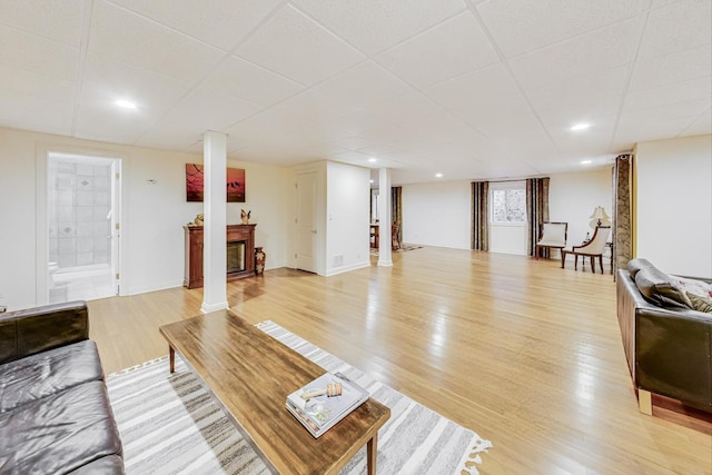 living area featuring light wood finished floors, recessed lighting, decorative columns, and baseboards