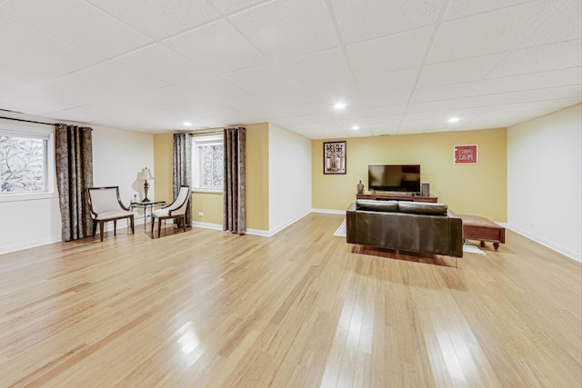 living area featuring plenty of natural light, light wood-style flooring, and baseboards