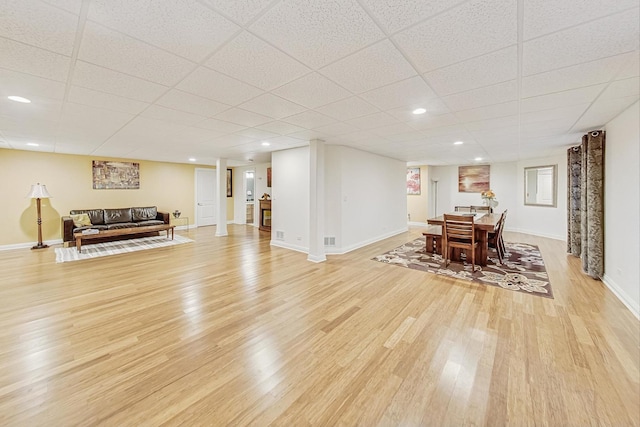 dining space featuring recessed lighting, light wood-type flooring, a paneled ceiling, and baseboards