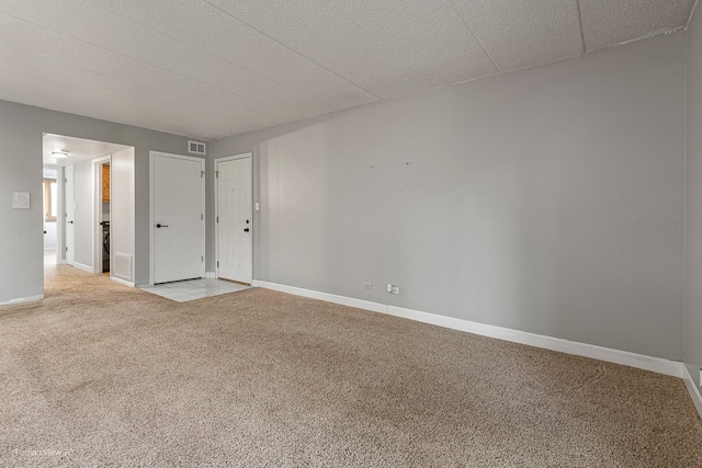 spare room with light carpet and a textured ceiling