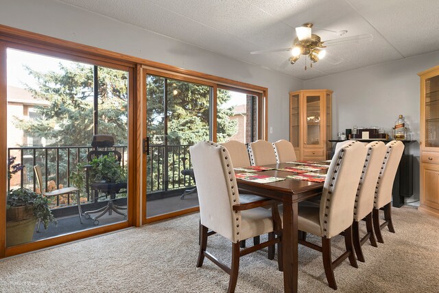 carpeted dining area featuring ceiling fan and a textured ceiling