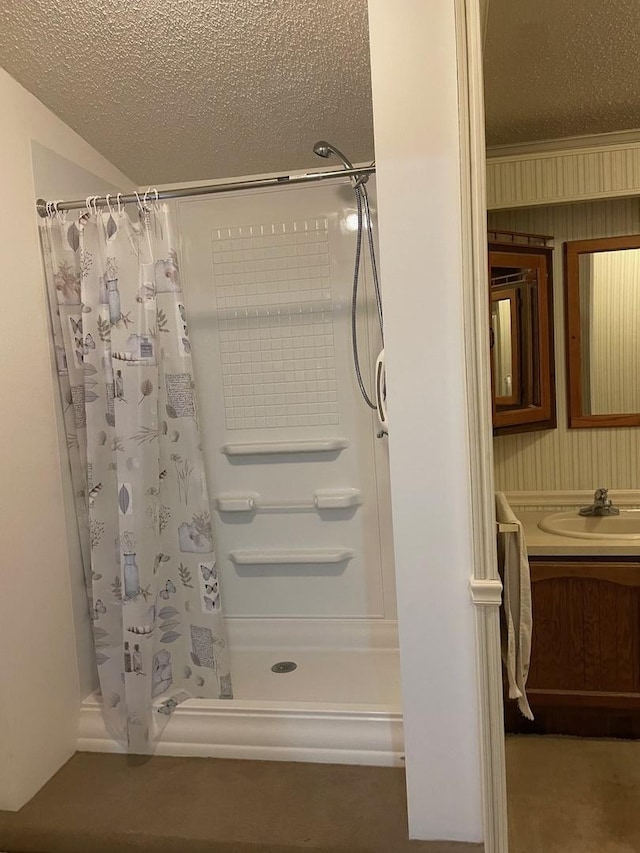 bathroom featuring vanity, curtained shower, and a textured ceiling