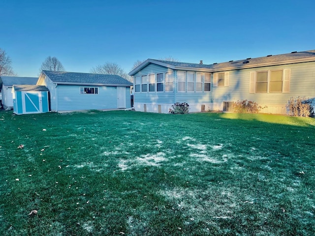 rear view of house with a sunroom, a shed, and a lawn