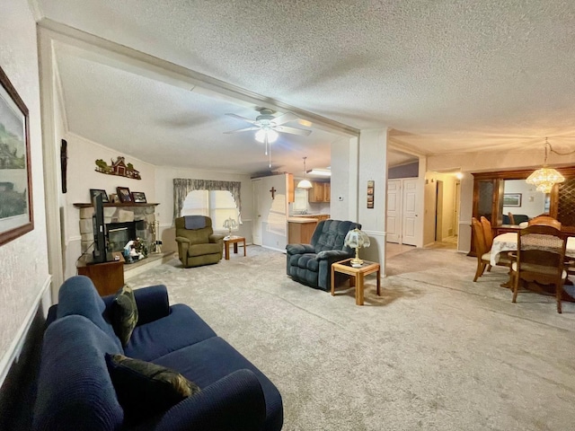 living room featuring ceiling fan, a fireplace, carpet, and a textured ceiling