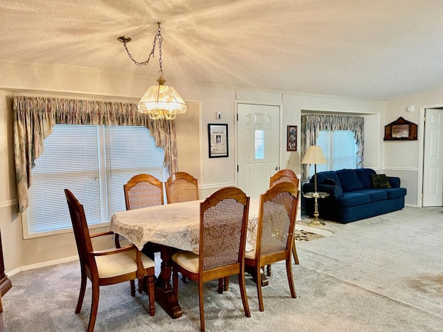 dining space featuring carpet, a textured ceiling, and a notable chandelier