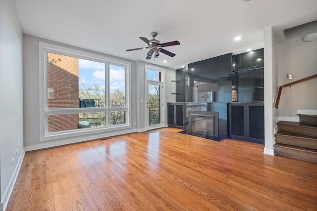 unfurnished living room with hardwood / wood-style flooring and ceiling fan