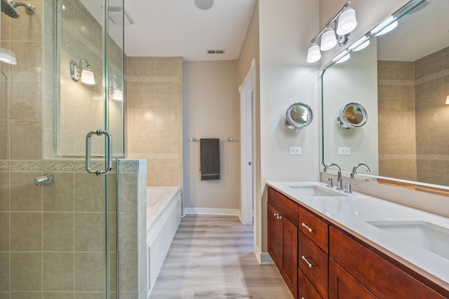 bathroom featuring wood-type flooring, vanity, and shower with separate bathtub