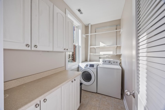 washroom with washer and clothes dryer, cabinets, light tile patterned floors, and a wealth of natural light