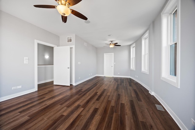 unfurnished living room featuring ceiling fan and dark hardwood / wood-style floors