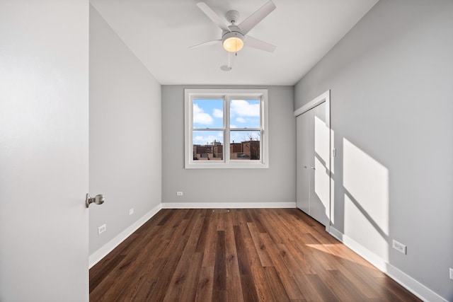 spare room with ceiling fan and dark hardwood / wood-style flooring