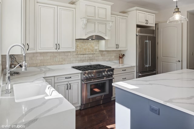 kitchen featuring dark hardwood / wood-style flooring, light stone counters, custom range hood, high quality appliances, and hanging light fixtures