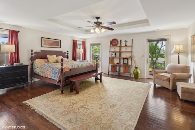 bedroom with a raised ceiling, access to exterior, ceiling fan, and dark hardwood / wood-style flooring