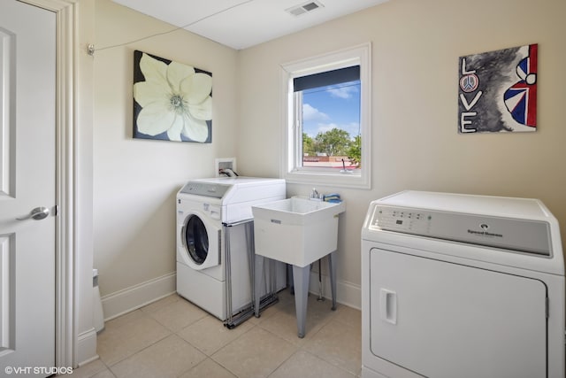 laundry area featuring washer and dryer and light tile patterned floors