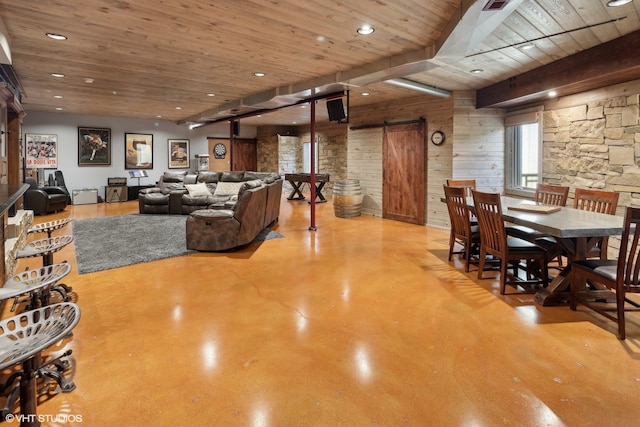 living room featuring a barn door, wooden walls, and wooden ceiling