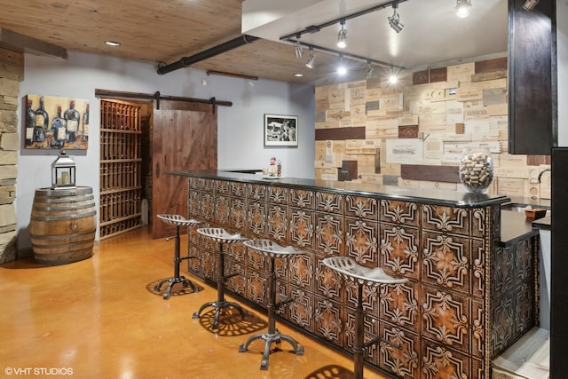 bar featuring a barn door and concrete flooring