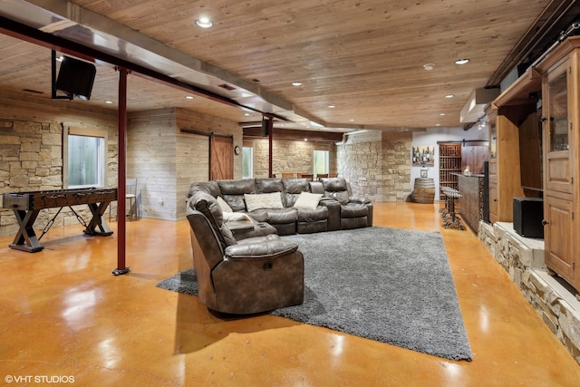 living room featuring a barn door, wood walls, and wooden ceiling