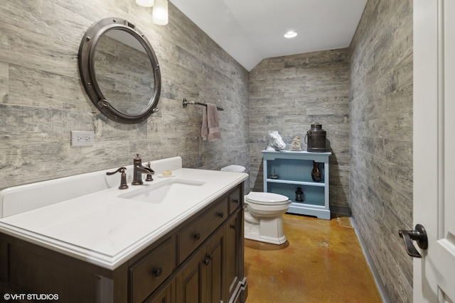 bathroom with vanity, concrete floors, tile walls, and toilet