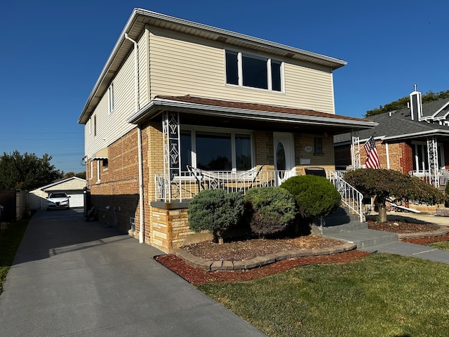 view of front facade with covered porch, a garage, a front lawn, and an outdoor structure