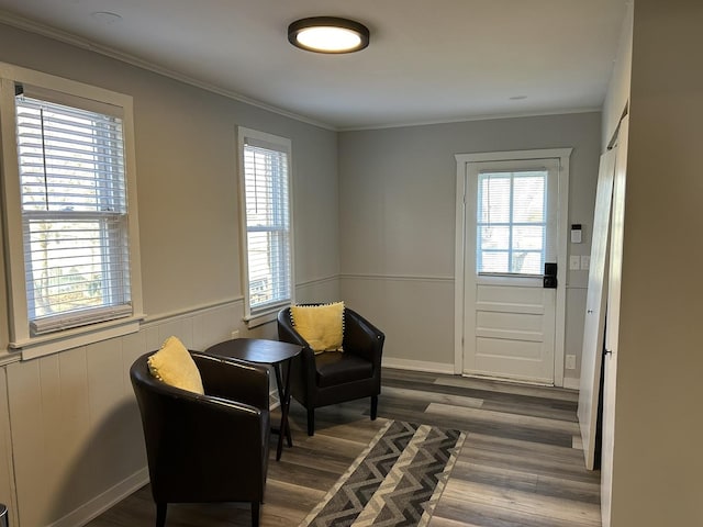 living area with dark hardwood / wood-style floors, a healthy amount of sunlight, and crown molding