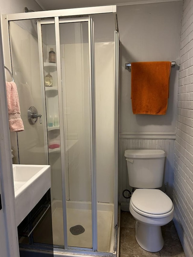 bathroom with toilet and a shower with door