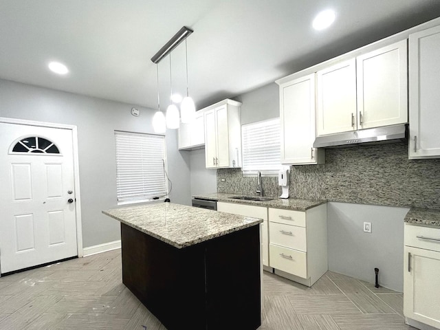 kitchen featuring a kitchen island, sink, dishwasher, white cabinetry, and hanging light fixtures