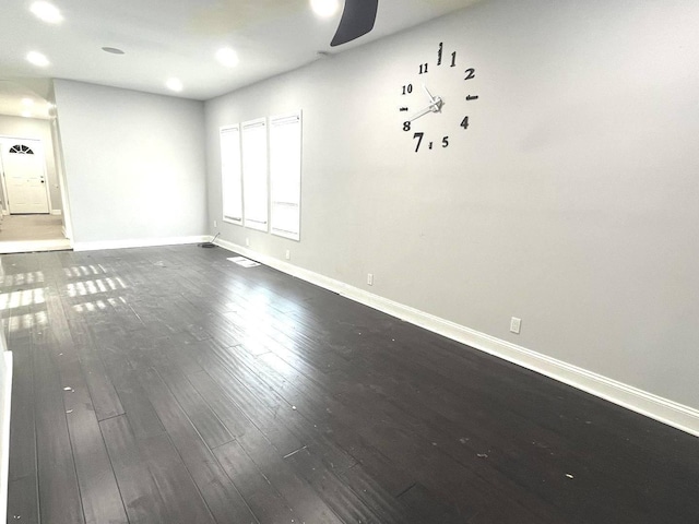 empty room with ceiling fan and dark hardwood / wood-style flooring