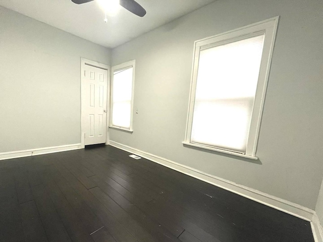 spare room with ceiling fan and dark wood-type flooring