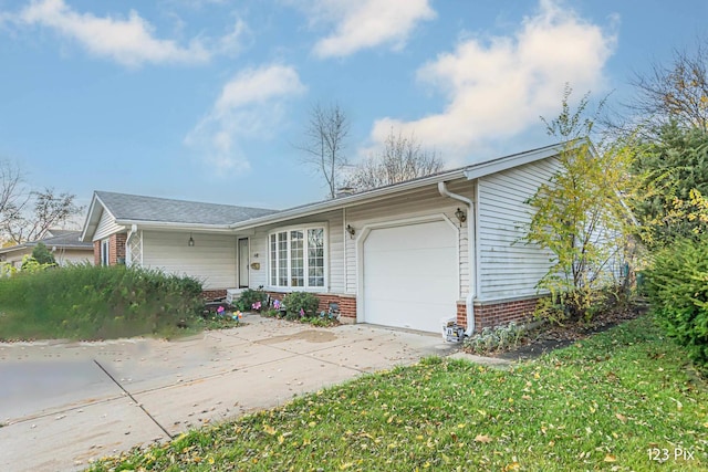 single story home featuring brick siding, a garage, and driveway