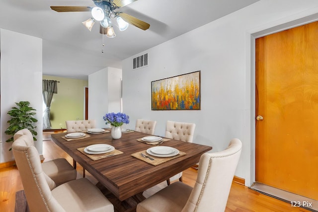 dining room with ceiling fan, visible vents, baseboards, and light wood-type flooring