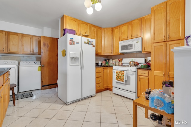 kitchen featuring tasteful backsplash, light tile patterned floors, white appliances, and independent washer and dryer