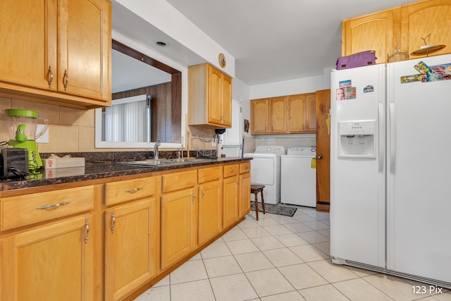 kitchen with separate washer and dryer, white fridge with ice dispenser, a healthy amount of sunlight, and sink