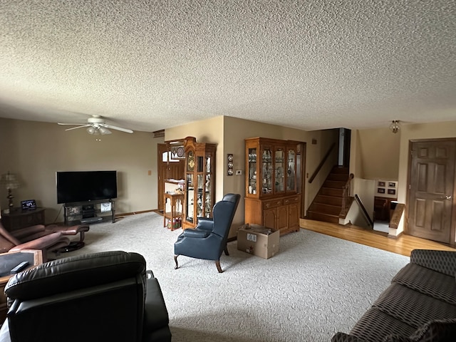 living room with ceiling fan, carpet floors, and a textured ceiling