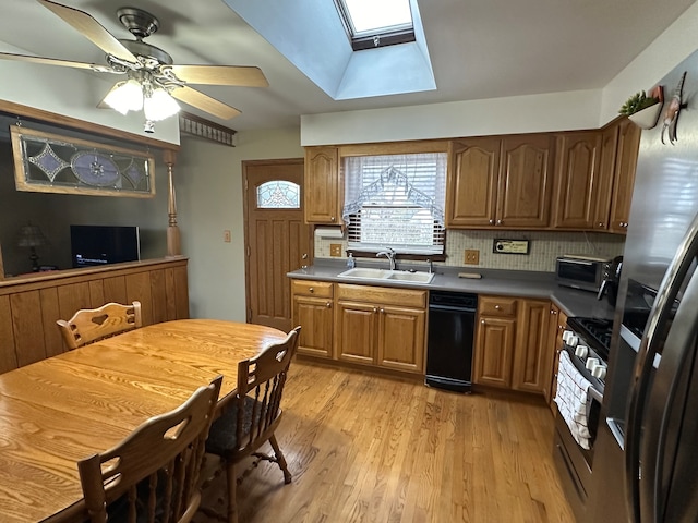 kitchen featuring sink, light hardwood / wood-style flooring, a skylight, decorative backsplash, and stainless steel appliances